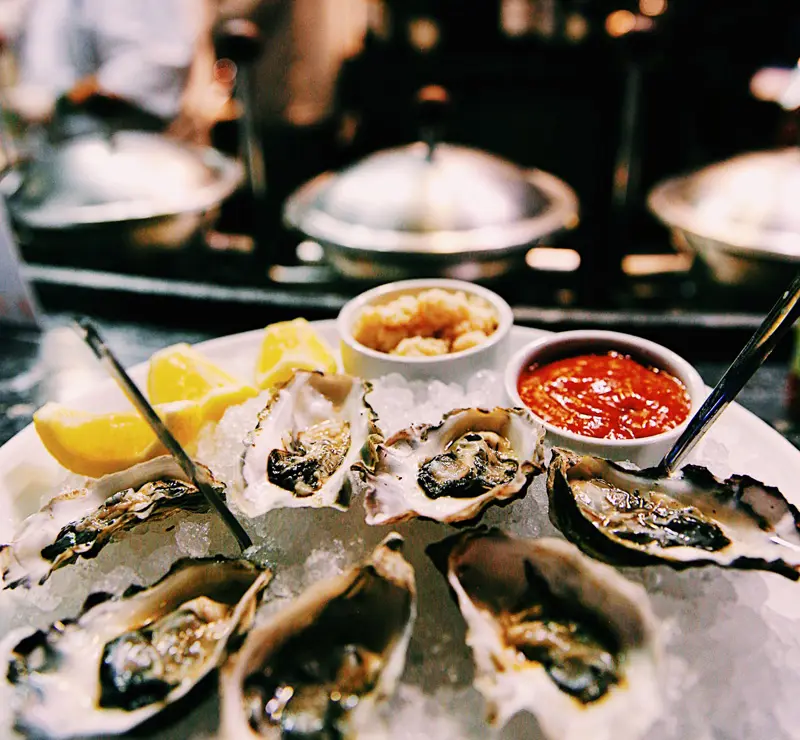 Seafood platter with mussels, lemon, sides, and sauces